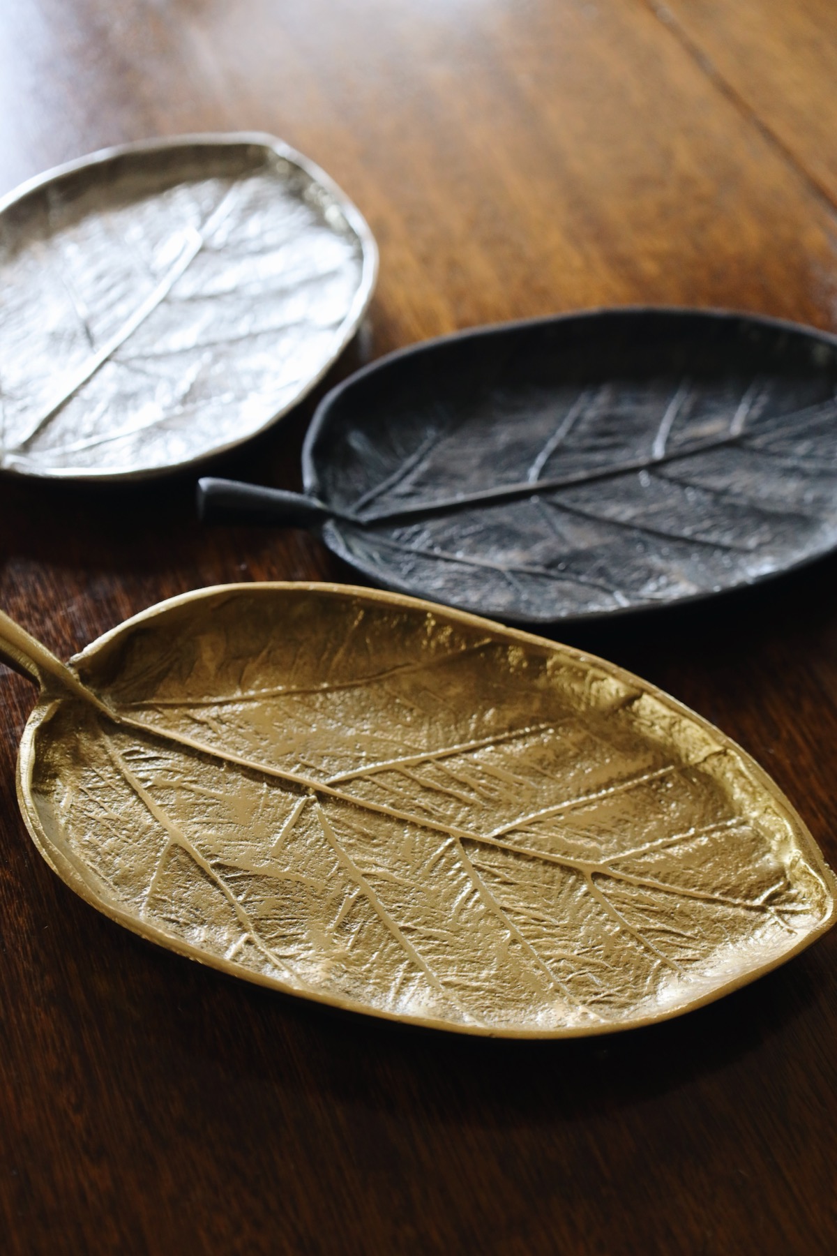 Leaf-shaped handmade ceramic plates on a wood table