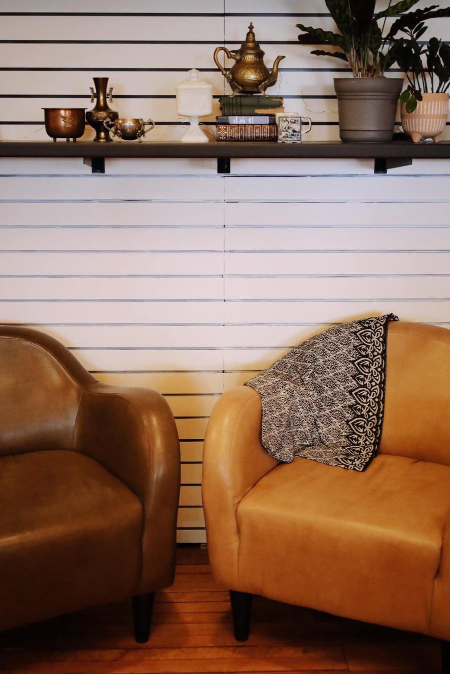 Leather chairs and brass decor shelf